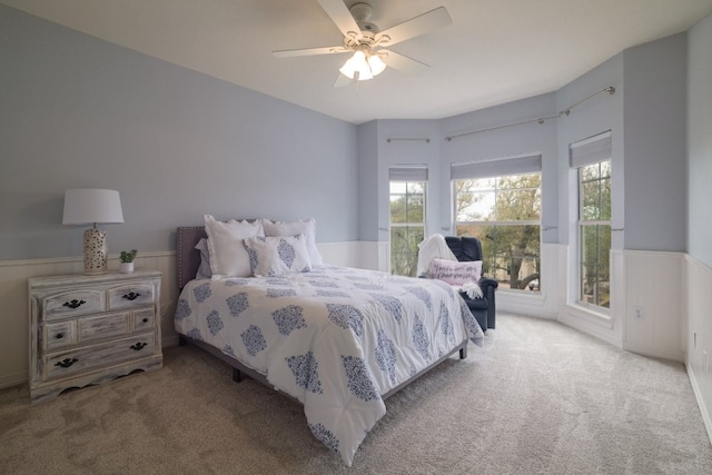 10204 Treasure Island Dr, Austin, TX 78730 - bedroom with carpet floors, multiple windows, a wainscoted wall, and a ceiling fan
