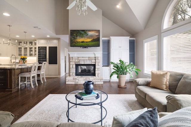 10204 Treasure Island Dr, Austin, TX 78730 - living area featuring dark wood-style floors, high vaulted ceiling, recessed lighting, a stone fireplace, and a chandelier