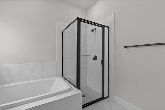 8408 Bouvreuil Dr, Austin, TX 78738 - bathroom featuring a bath, a stall shower, marble finish floors, and baseboards