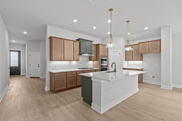8408 Bouvreuil Dr, Austin, TX 78738 - kitchen featuring a sink, appliances with stainless steel finishes, brown cabinetry, light wood-style floors, and recessed lighting