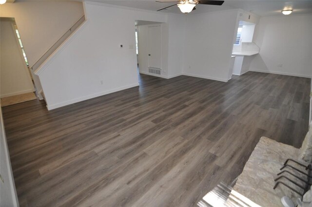 12223 Antoinette Pl, Austin, TX 78727 - unfurnished living room with stairs, crown molding, a ceiling fan, dark wood finished floors, and baseboards
