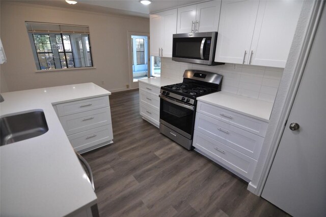 12223 Antoinette Pl, Austin, TX 78727 - kitchen featuring dark wood-style flooring, decorative backsplash, a sink, white cabinets, and appliances with stainless steel finishes