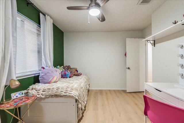8614 Croydon Loop, Austin, TX 78748 - bedroom featuring light wood-style floors, multiple windows, a ceiling fan, and a textured ceiling