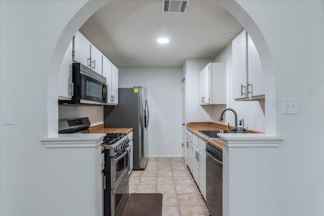 8614 Croydon Loop, Austin, TX 78748 - kitchen with black microwave, double oven range, dishwasher, white cabinetry, and a textured ceiling