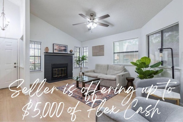 8614 Croydon Loop, Austin, TX 78748 - living room featuring wood finished floors, ceiling fan, lofted ceiling, healthy amount of natural light, and a fireplace with flush hearth