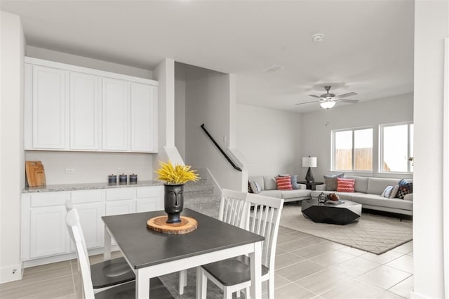 dining room with stairs, ceiling fan, and light tile patterned floors