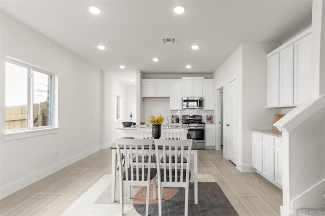 kitchen featuring stainless steel appliances, light tile patterned floors, white cabinets, light countertops, and recessed lighting