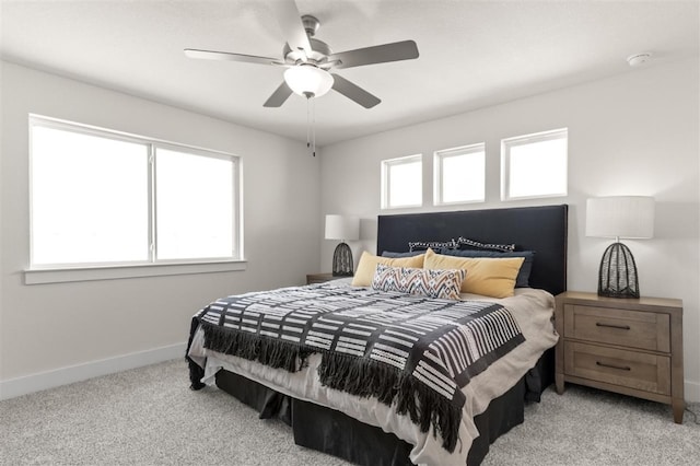 bedroom featuring baseboards, light colored carpet, and ceiling fan