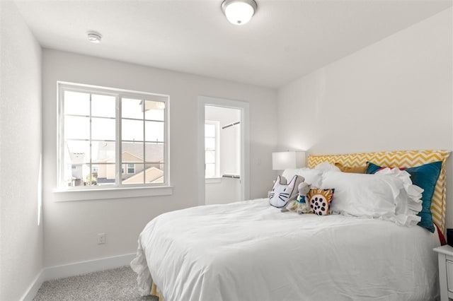 bedroom with baseboards and carpet