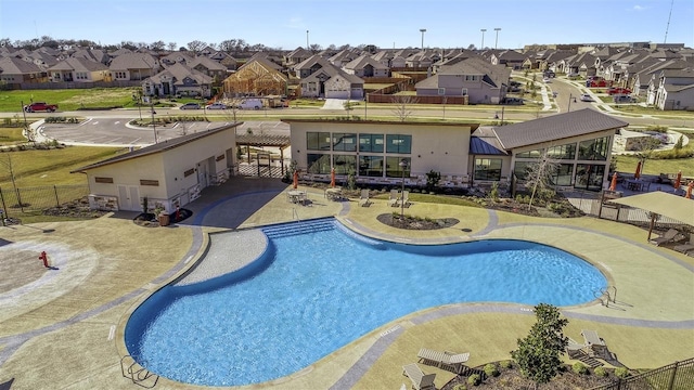 community pool featuring a residential view, fence, and a patio area