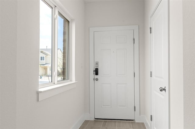 doorway to outside featuring plenty of natural light and baseboards