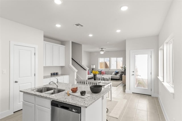 kitchen featuring stainless steel dishwasher, a sink, white cabinetry, baseboards, and recessed lighting
