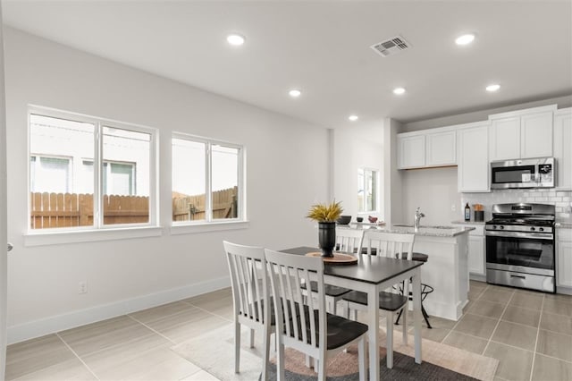 kitchen featuring appliances with stainless steel finishes, light tile patterned floors, recessed lighting, tasteful backsplash, and white cabinetry