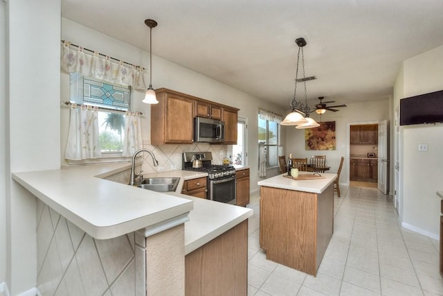 2435 Candle Ridge Trl, Georgetown, TX 78626 - kitchen with light countertops, a sink, appliances with stainless steel finishes, a center island, and brown cabinets