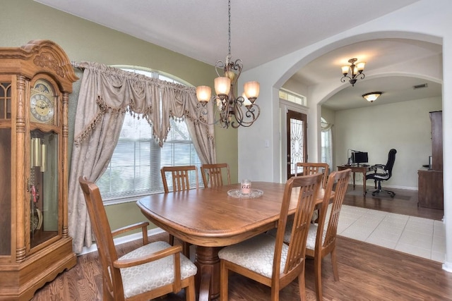 2435 Candle Ridge Trl, Georgetown, TX 78626 - dining area featuring baseboards, arched walkways, visible vents, a notable chandelier, and wood finished floors