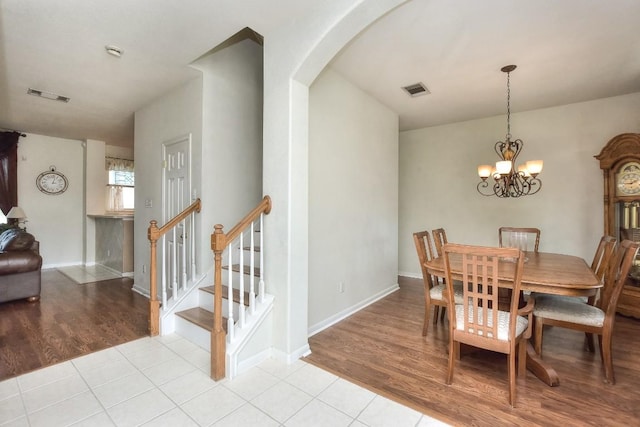 2435 Candle Ridge Trl, Georgetown, TX 78626 - dining room featuring light wood finished floors, visible vents, arched walkways, and a chandelier