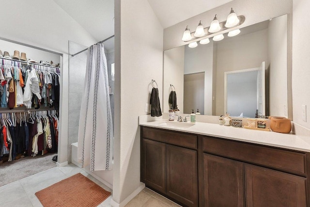 full bathroom with tile patterned flooring, a walk in closet, lofted ceiling, and vanity