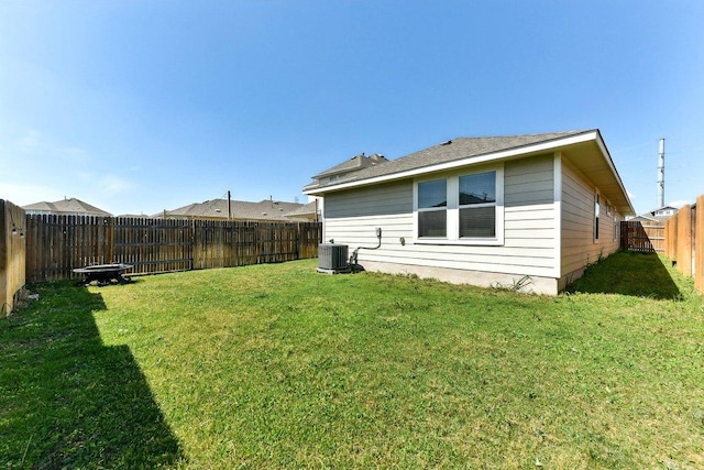 exterior space with a lawn, central AC unit, and a fenced backyard