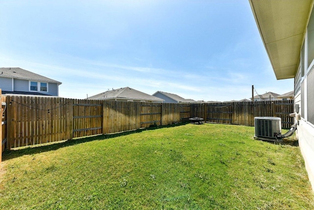 view of yard featuring central AC and a fenced backyard