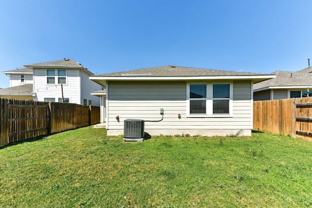 rear view of property featuring a fenced backyard, central air condition unit, and a yard