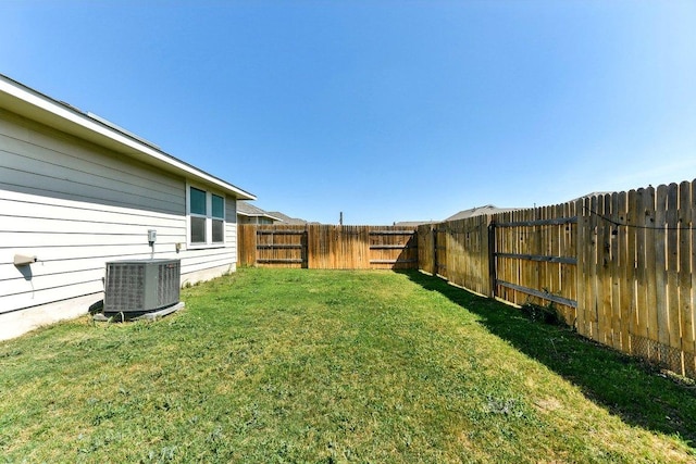 view of yard with central air condition unit and a fenced backyard