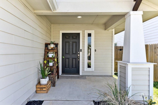 property entrance featuring a porch and fence