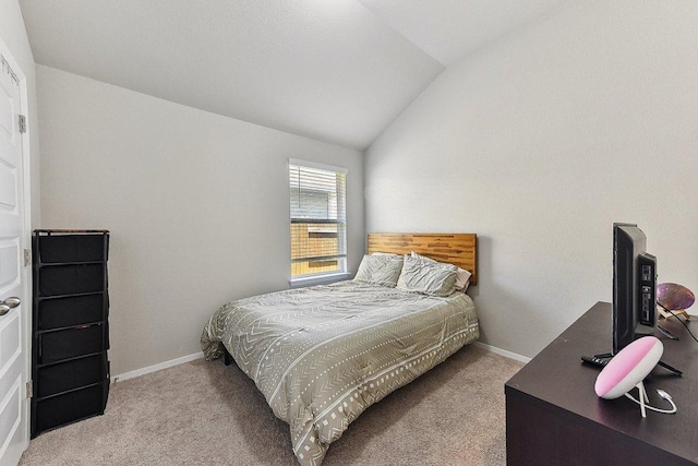 bedroom with baseboards, vaulted ceiling, and carpet flooring