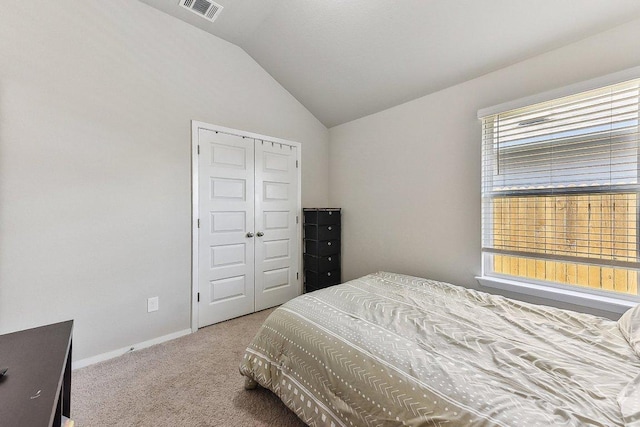 bedroom featuring visible vents, vaulted ceiling, baseboards, a closet, and carpet flooring
