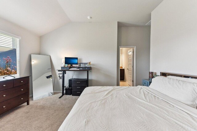 bedroom featuring carpet floors, ensuite bath, and lofted ceiling