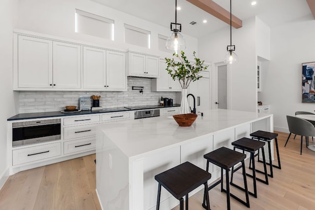 13408 Galleria Cir, Austin, TX 78738 - kitchen with a sink, backsplash, white cabinets, a breakfast bar, and light wood-style floors