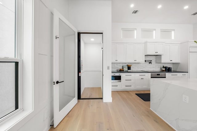 13408 Galleria Cir, Austin, TX 78738 - kitchen featuring decorative backsplash, white cabinetry, light wood-style floors, recessed lighting, and black electric stovetop