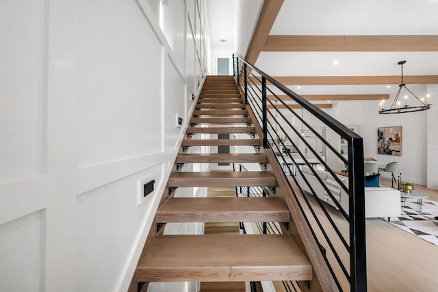 13408 Galleria Cir, Austin, TX 78738 - staircase featuring a chandelier, wood finished floors, and beamed ceiling