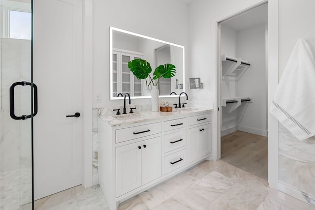13408 Galleria Cir, Austin, TX 78738 - bathroom with double vanity, marble finish floors, a spacious closet, a marble finish shower, and baseboards