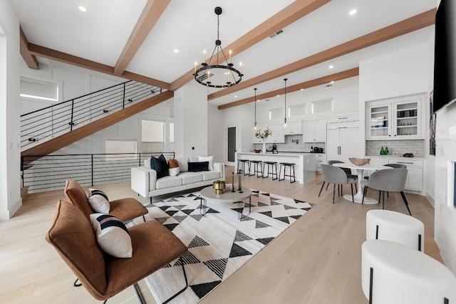 13408 Galleria Cir, Austin, TX 78738 - living room featuring beamed ceiling, a chandelier, light wood-style floors, recessed lighting, and a towering ceiling