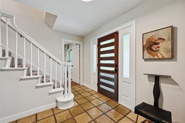 entryway with stairway and baseboards