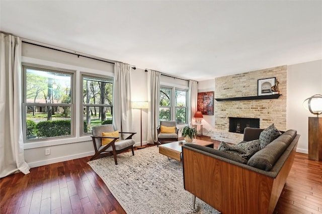 living area featuring a fireplace, dark wood-type flooring, and baseboards