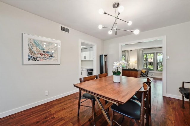 dining area with a chandelier, dark wood-style floors, and baseboards