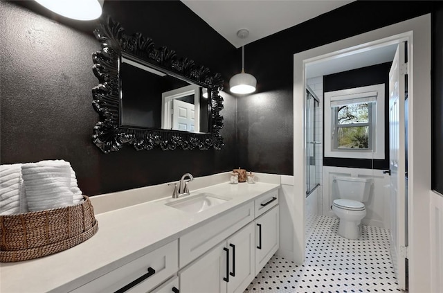 full bath with toilet, vanity, bath / shower combo with glass door, and tile patterned flooring