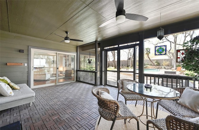 sunroom / solarium featuring a ceiling fan