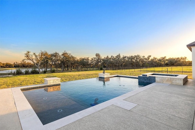 view of swimming pool with fence, a lawn, a patio area, and a pool with connected hot tub