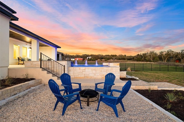 yard at dusk featuring fence and an outdoor fire pit