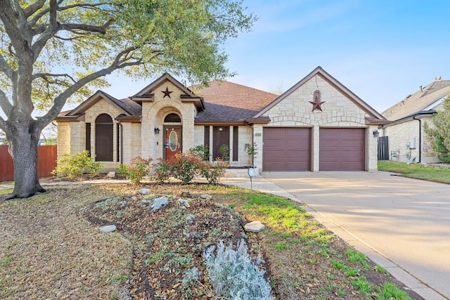 15835 Garrison Cir, Austin, TX 78717 - french country home with stone siding, an attached garage, concrete driveway, and roof with shingles
