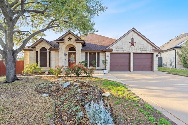 15835 Garrison Cir, Austin, TX 78717 - french country style house with stone siding, an attached garage, driveway, and roof with shingles