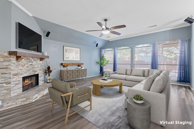 living room featuring a fireplace, ceiling fan, visible vents, vaulted ceiling, and wood finished floors