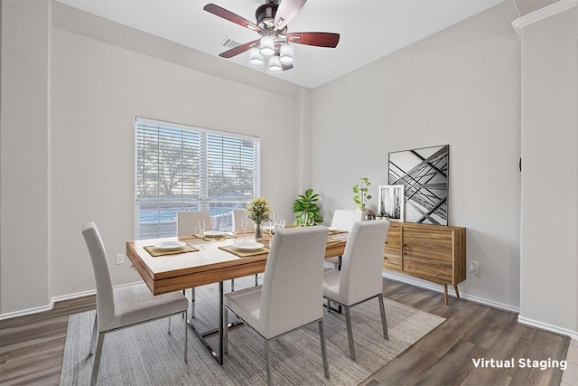 dining room with wood finished floors, a ceiling fan, and baseboards
