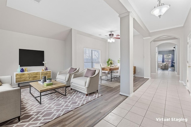 living room featuring ornamental molding, ceiling fan, light wood-style floors, and a healthy amount of sunlight