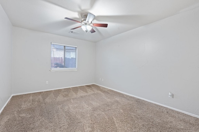 spare room with carpet, visible vents, ceiling fan, and baseboards