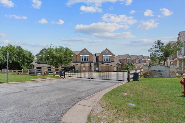 view of street with a residential view, a gated entry, a gate, and curbs