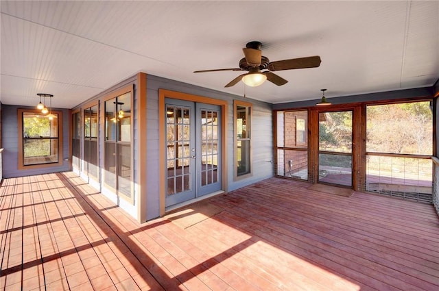 unfurnished sunroom with a ceiling fan and french doors