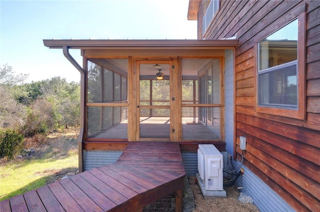 wooden deck with a sunroom and ac unit
